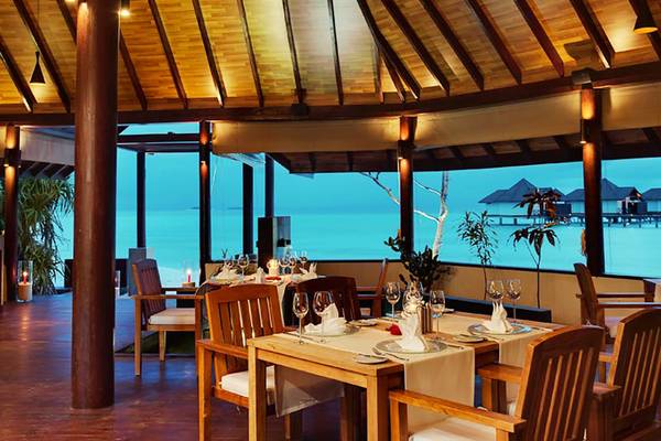 Innenansicht des Robinson Maldives Hotel Restaurants mit Blick auf den Ozean.