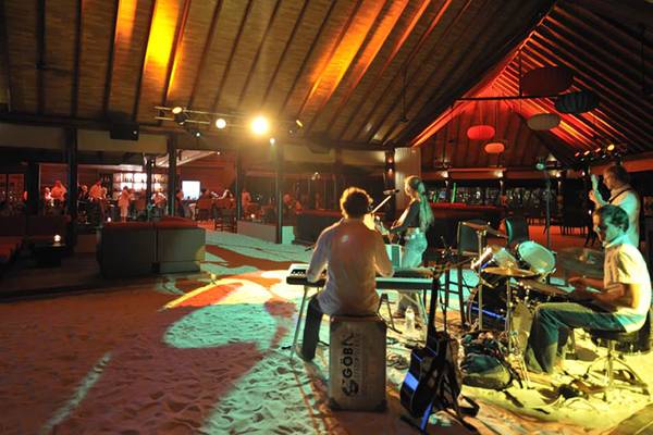 Band spielt auf dem Sand vor dem Robinson Maldives Hotel.