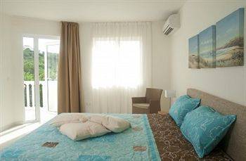 Schlafzimmer im Blue Bay Curacao Golf & Beach Resort mit Bett, Kissen, Stuhl und Klimaanlage.