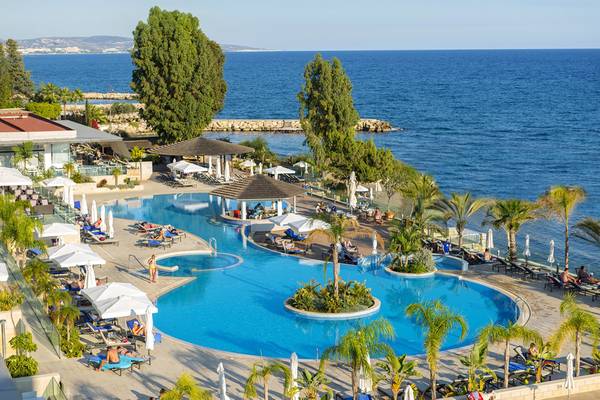 Überblick über den Poolbereich des Royal Apollonia Beach Hotels mit blauem Wasser und Sonnenliegen.