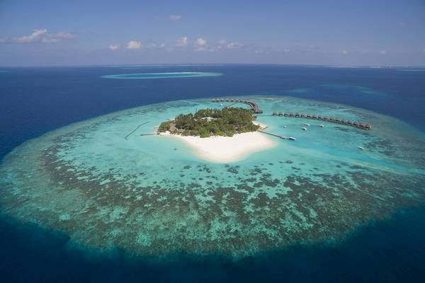 Luftaufnahme des Thulhagiri Island Resorts mit mehreren Wasserbungalows und blauem Ozean