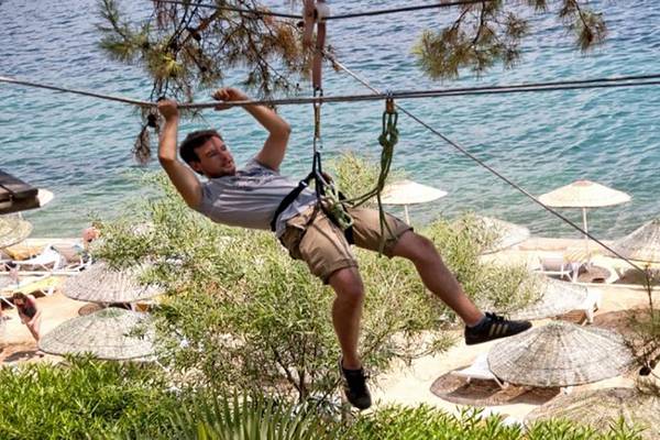 Ein Mann, der sich an einer Seilbahn im Grand Yazici Club Marmaris Palace festhält.