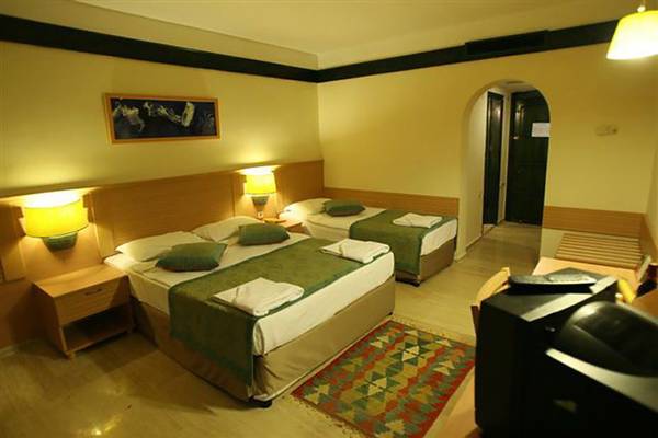 Doppelzimmer im Grand Yazici Club Marmaris Palace mit zwei Betten, Nachttischen und Fernseher.