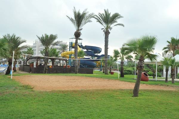 Außenbereich des Adams Beach Hotels mit Wasserrutsche und Volleyballfeld