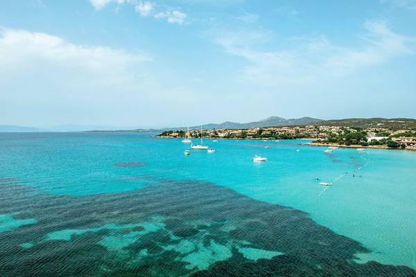 Luftaufnahme des Gabbiano Azzurro Hotels mit Blick auf das blaue Meer und mehrere Boote.