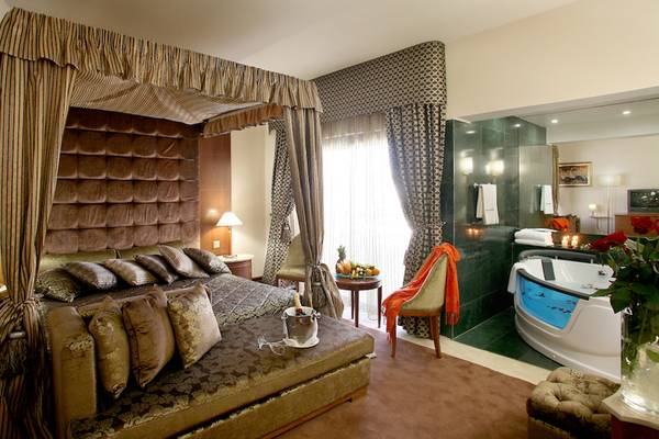 Schlafzimmer im Adams Beach Hotel mit Himmelbett, Badewanne und Dekor