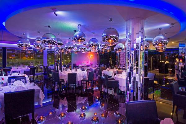 Innenansicht des Adams Beach Hotel Restaurants mit vielen runden Leuchten und blauer Beleuchtung.
