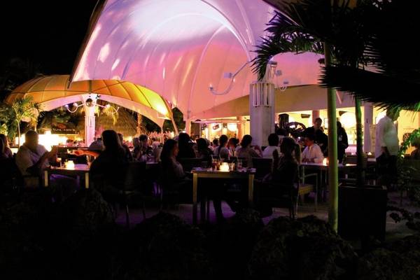 Van der Valk Kontiki Beach Resort Curaçao - Gäste sitzen bei Nachtessen unter der Kuppel.