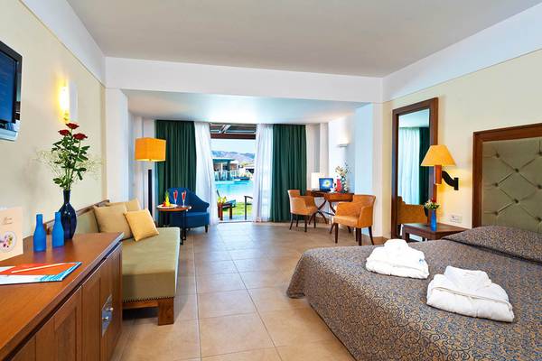 Hotelzimmer im Giannoulis Cavo Spada Sports & Leisure Resort mit Doppelbett, Couch, Fernseher und Poolblick