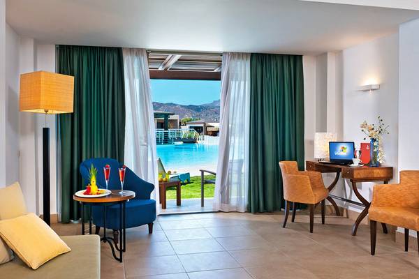 Innenansicht eines Zimmers im Giannoulis Cavo Spada Sports & Leisure Resort mit Blick auf den Pool.
