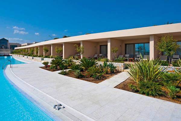 Außenansicht des Giannoulis Cavo Spada Sports & Leisure Resorts mit Swimmingpool und Sonnenliegen.