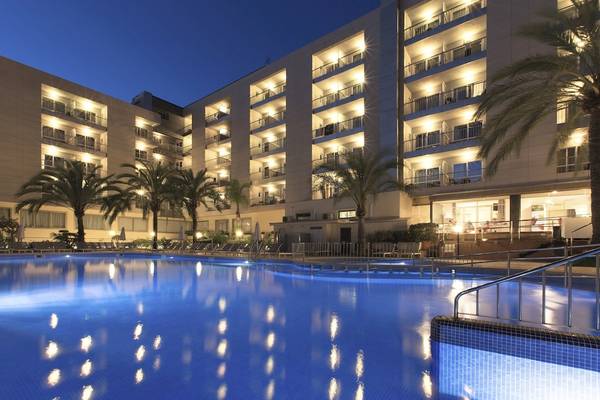 Abendansicht des Swimmingpools des Cosmopolitan Hotels mit leuchtenden Zimmern und Palmen