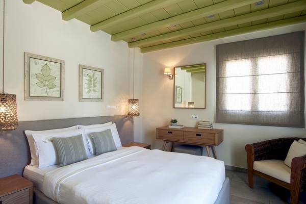 Schlafzimmer im Vencia Boutique Hotel mit grüner Decke, Bett, Nachttischen und einem Fenster.