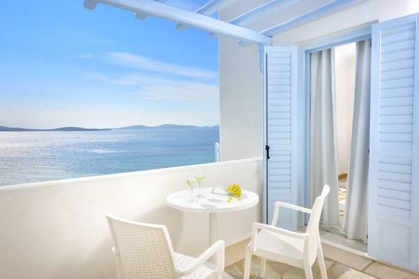 Balkon des Vencia Boutique Hotels mit Meerblick, zwei weißen Stühlen und einem Tisch.