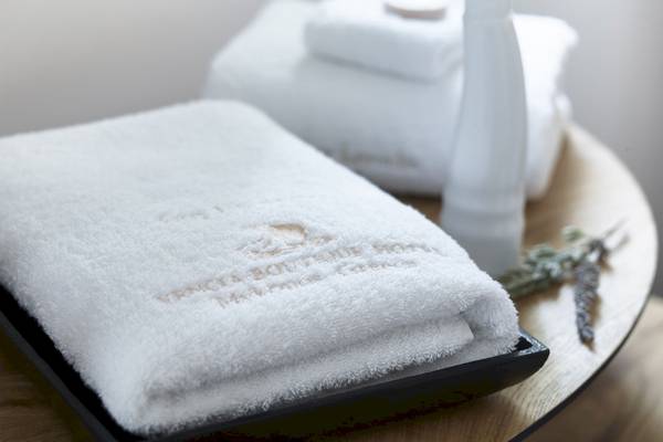 Vencia Boutique Hotel Handtücher auf einem Tisch, umgeben von Lavendel und einer Vase.