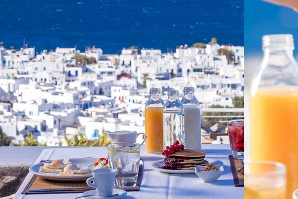 Ansicht vom Hotel Vencia Boutique mit Frühstücksbuffet und Getränken auf einer Terrasse mit Meerblick.