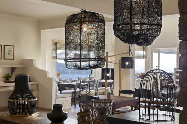 Inneneinrichtung des Vencia Boutique Hotels mit schwarzen Lampen, Tischen und Stühlen.