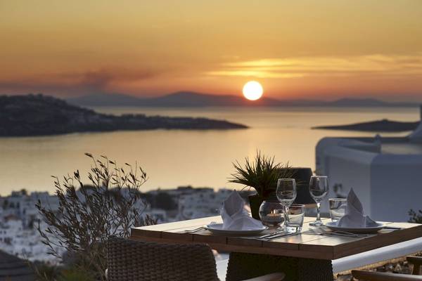 Sonnenuntergang im Vencia Boutique Hotel mit Tisch, Geschirr und Blick aufs Meer.
