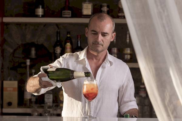 Ein Barkeeper gießt einen Cocktail in einen Kelch im Vencia Boutique Hotel.