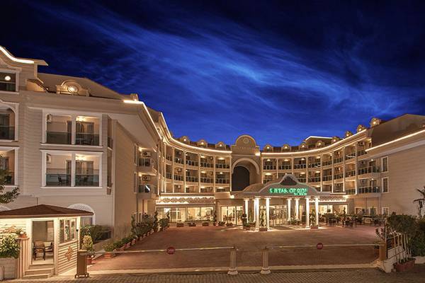 Der Eingangsbereich des Sultan of Side Hotels bei Nacht mit blauem Himmel und Beleuchtung