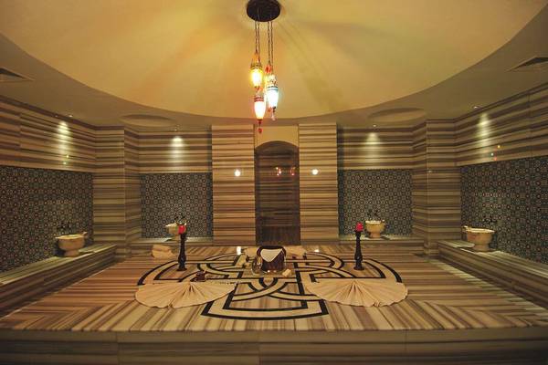 Innenbereich der Sauna im Commodore Elite Suites & Spa mit Marmorboden und blauen Wandfliesen.