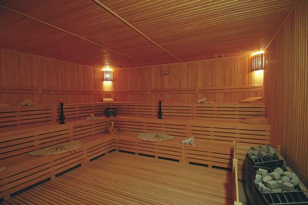 Saunaraum im Commodore Elite Suites & Spa mit Holzwänden und Bänken.