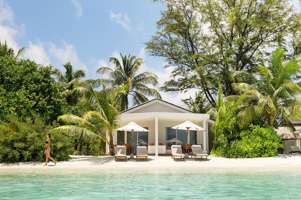 Villa am Strand des LUX South Ari Atoll Hotels mit Frau und Palmen