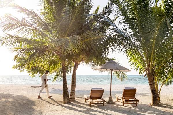 Strand mit Palmen und Sonnenschirmen am LUX South Ari Atoll