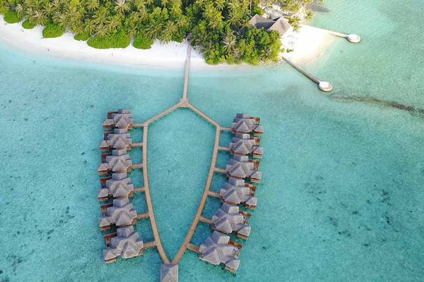 Luftaufnahme des Fihalhohi Island Resorts mit Wasserbungalows und grüner Insel