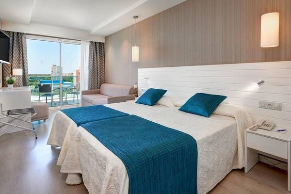 Doppelzimmer im Hipotels Said mit zwei Betten, blauen Kissen und Blick auf die Terrasse.