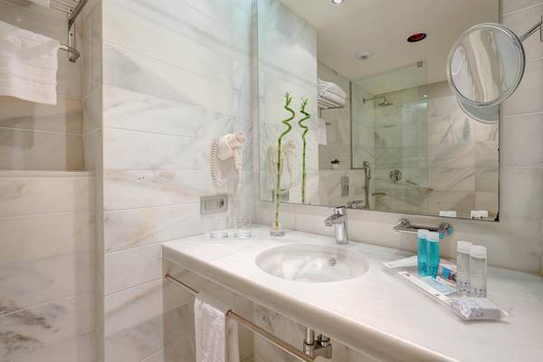 Badezimmer des Hipotels Said mit weißem Marmor, Spiegel und Toilettenartikeln