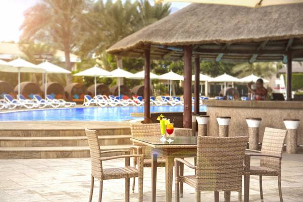 Barbereich am Pool des Fujairah Rotana Resorts mit Cocktails und Sonnenschirmen