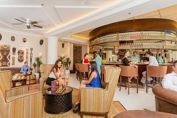 Lounge Bereich im Fujairah Rotana Resort & Spa mit Gästen und Bar.