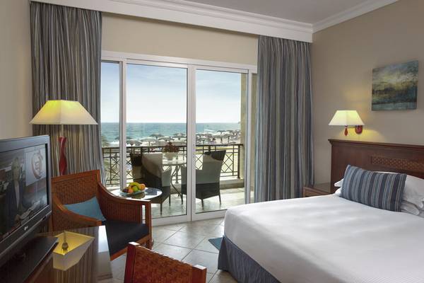 Zimmer im Fujairah Rotana Resort & Spa mit Blick auf das Meer und eine Terrasse.