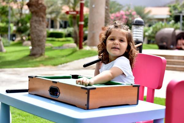 Kleines Kind spielt Pool im Freien im Fujairah Rotana Resort & Spa