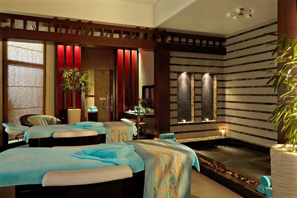 Massagebereich im Fujairah Rotana Resort & Spa mit zwei Massageliegen und einem Whirlpool.