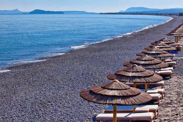 Avra Imperial Hotel Strand mit Sonnenliegen und Sonnenschirmen am schwarzen Sand