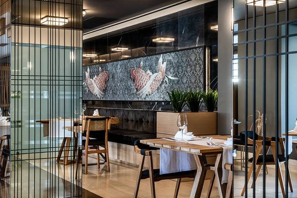 Innenbereich des Avra Imperial Hotels mit kunstvollen Koi-Fisch-Wandmalereien.