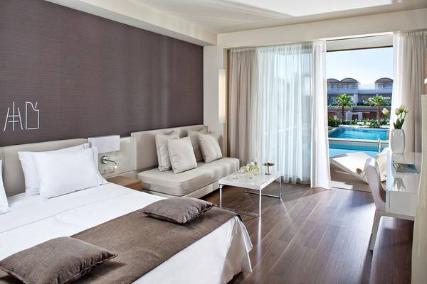 Innenansicht eines Hotelzimmers im Avra Imperial Hotel mit Blick auf den Pool.