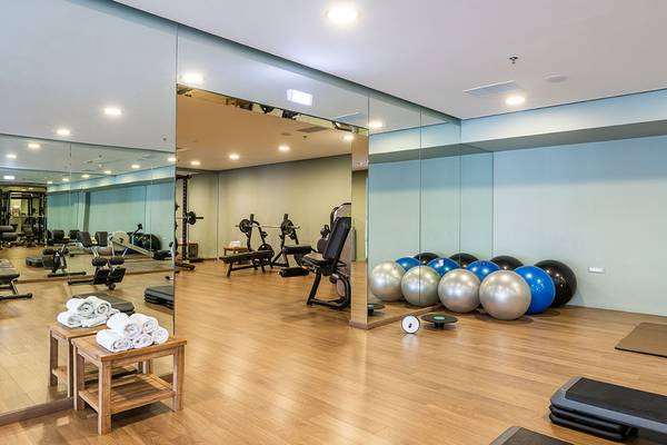 Innenansicht des Fitnessstudios im Avra Imperial Hotel mit Spiegeln, Trainingsgeräten und Gymnastikbällen.