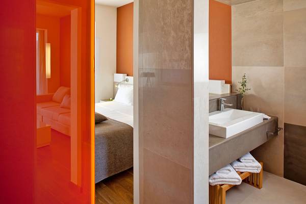 Badezimmer mit orangener Wand im Avra Imperial Hotel