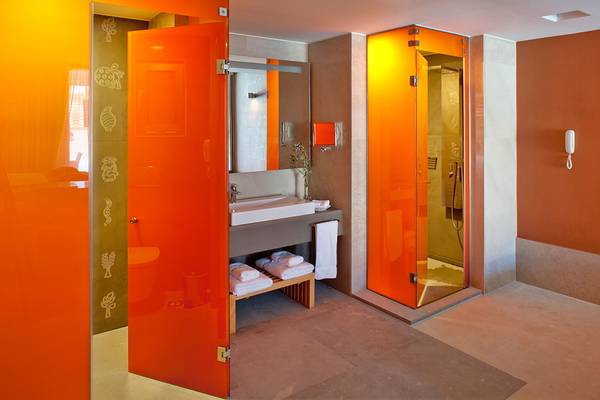 Badezimmer im Avra Imperial Hotel mit orangefarbenen Wänden und modernen Möbeln.