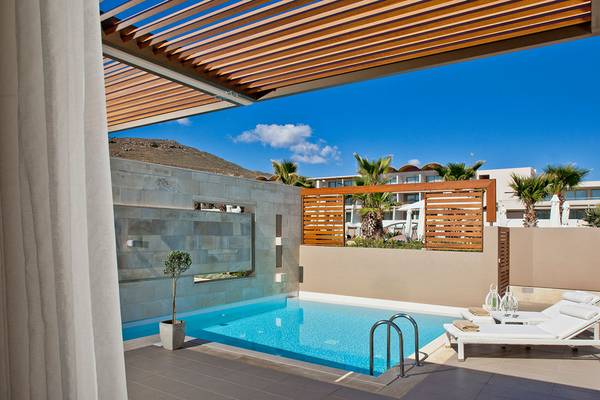 Außenbereich des Avra Imperial Hotels mit Swimmingpool und Loungebereich
