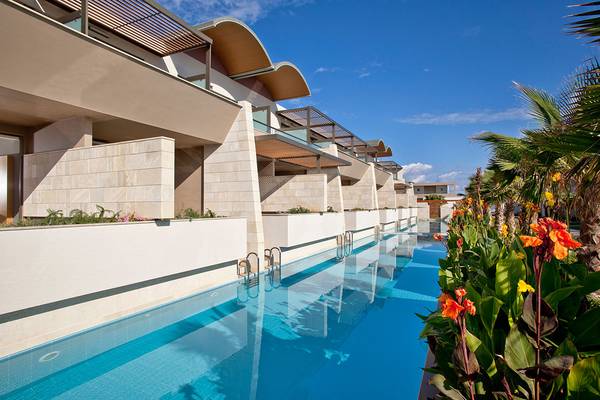 Außenansicht des Avra Imperial Hotels mit Swimmingpool und Pflanzen.