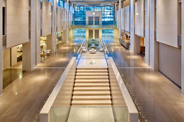 Innenansicht der Lobby des Avra Imperial Hotels mit Marmorboden und zentralen Treppen