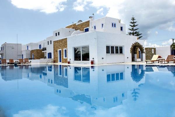 Naxos Holidays Hotel mit Pool und Liegestühlen unter blauem Himmel