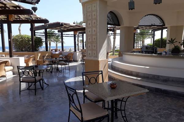 Loungebereich des Pickalbatros The Palace Port Ghalib mit Tischen, Stühlen und Blick auf das Meer.