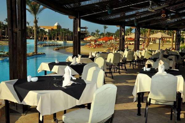 Außenrestaurant im Pickalbatros The Palace Port Ghalib Hotel mit Blick auf den Pool und die Palmen.