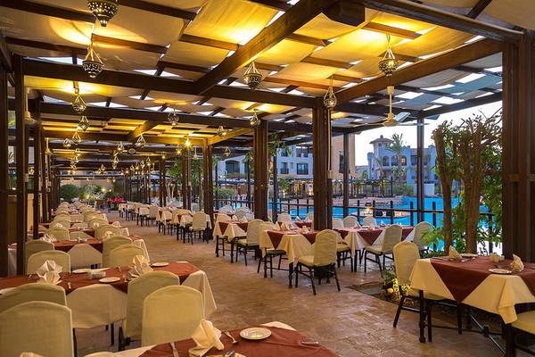 Restaurant im Pickalbatros The Palace Port Ghalib mit Tischen und Stühlen unter Pergolen