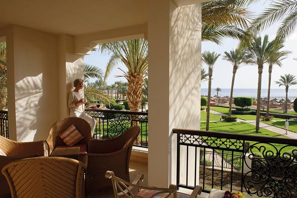 Ein Blick von der Terrasse des Hotels Pickalbatros The Palace Port Ghalib auf eine Frau und eine Palme.